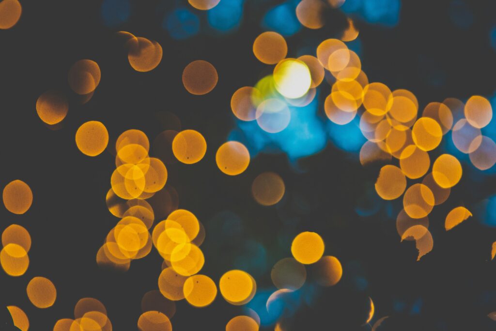 A mesmerizing display of golden bokeh lights against a dark and dreamy backdrop, perfect for festive themes.